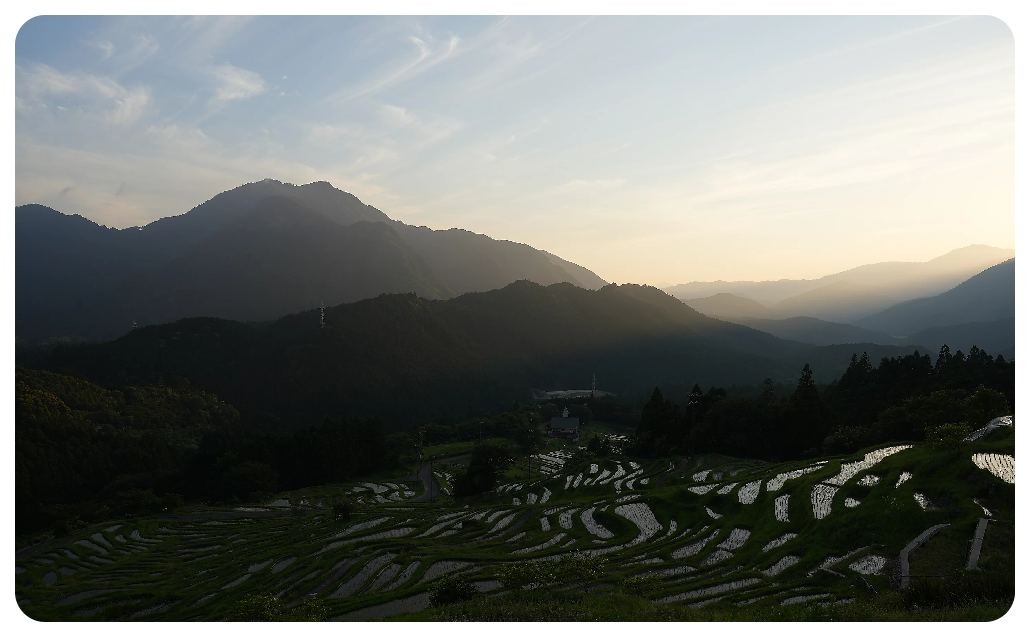 Sony A7 IV Sample image of stepped rice paddies on a mountain side with a valley of vast mountains in the distance